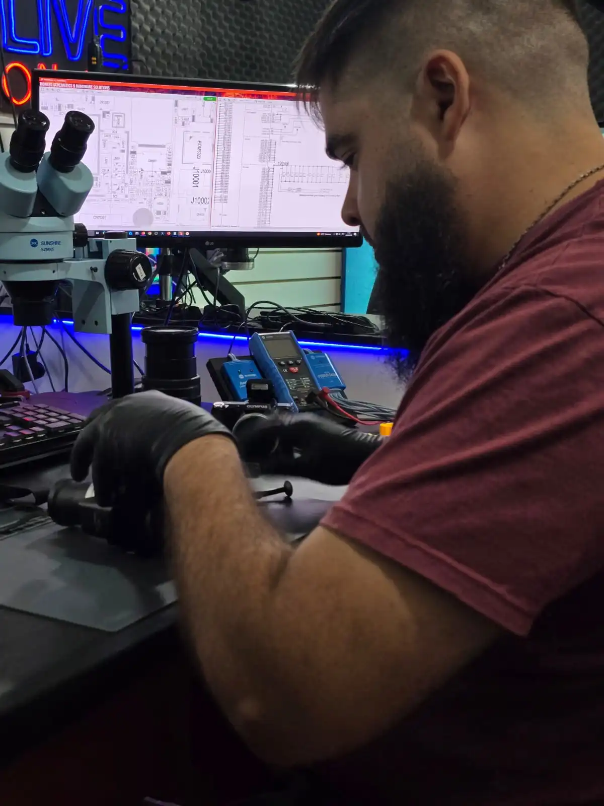 Técnico de Teotec realizando mantenimiento de precisión a un lente de cámara