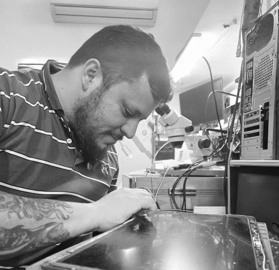 Marcelo Villar, de Full PC, trabajando con microscopio sobre la pantalla de una notebook